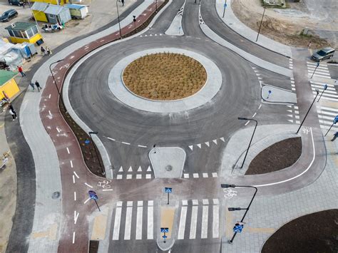 Šviesoforas su geltonu signalu ir automobiliais artėjančiais prie sankryžos