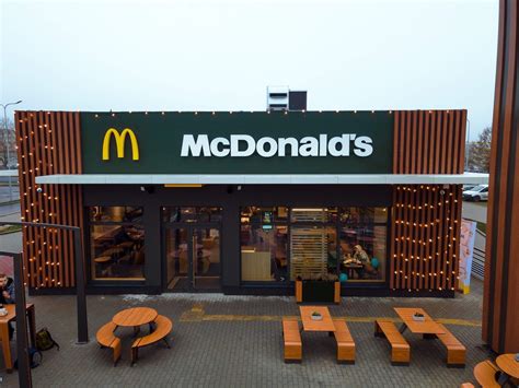 Darbuotojas „McDonald's“ virtuvėje ruošia mėsainį pagal standartizuotą procesą.