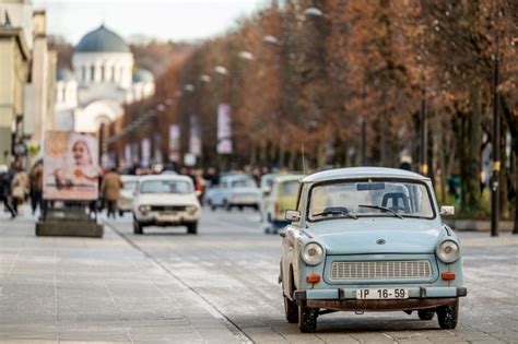 istorinė nuotrauka, vaizduojanti Berlyno sieną ir rytų vokiečių automobilius