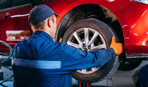 Bendras vaizdas autoserviso patalpose, kur meistrai atlieka automobilių techninę priežiūrą.