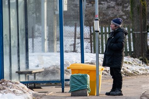Žmonės laukia autobuso stotelėje