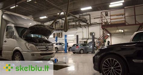 Autoserviso meistras atlieka automobilio kėbulo diagnostiką ir matavimus su specialia įranga.