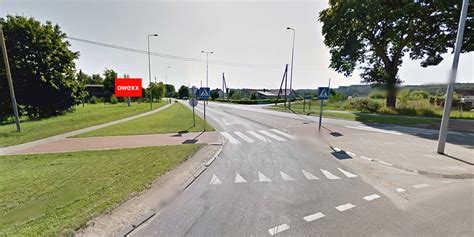 Nuotrauka, vaizduojanti nukabintą kelio ženklą prie garažų įvažiavimo