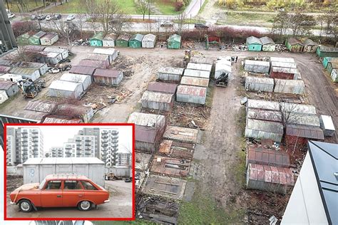 Šiukšlių ir senų automobilių detalių krūvos prie garažų