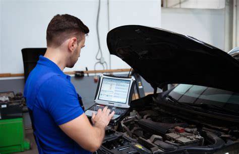 Fotografija, kurioje technikas, naudodamas diagnostikos įrangą, tikrina automobilį servise.