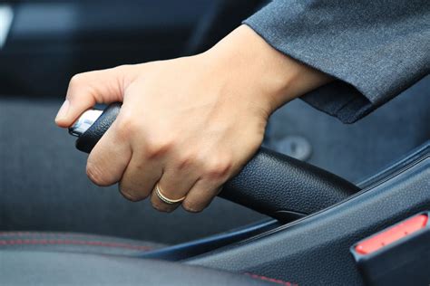 mechanikas, reguliuojantis rankinio stabdžio trosą po automobiliu