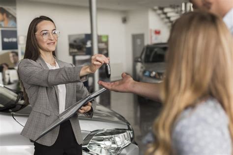 Tematinė nuotrauka: besišypsantis klientas su naujai įsigytu naudotu automobiliu