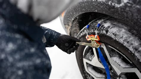 Automobilis su žieminėmis padangomis ir sniego grandinėmis Austrijos kalnų kelyje