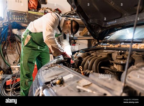 A mechanic performing maintenance on a car dashboard