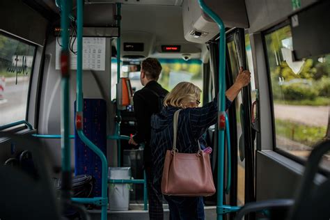 Paveikslėlis: keleiviai, besilaikantys už turėklų autobuse