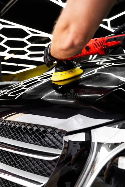 Thematic image of car glass being polished, close-up on a skilled worker's hands