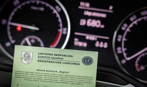Tematinė nuotrauka: žmogus laiko automobilio registracijos liudijimą