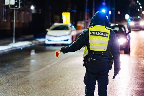 automobilis su greičio matuokliu ir policijos pareigūnu, simbolizuojantis KET pažeidimų fiksavimą