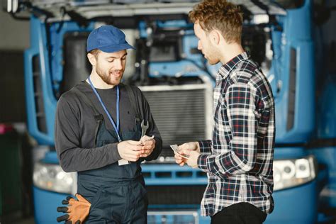 automobilio remonto scena su meistru ir klientu, pabrėžiant gedimo aptikimą