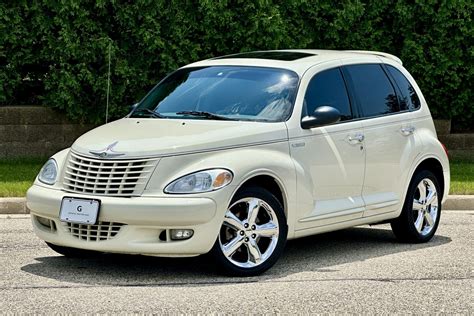 Chrysler PT Cruiser važiuojantis keliu, iliustruojantis automobilio išvaizdą kelyje