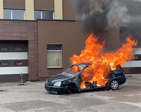 Ugniagesiai gesina degantį BMW automobilį didelio eismo vietoje