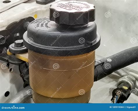 Close-up photo of a power steering fluid reservoir with MIN and MAX markings.