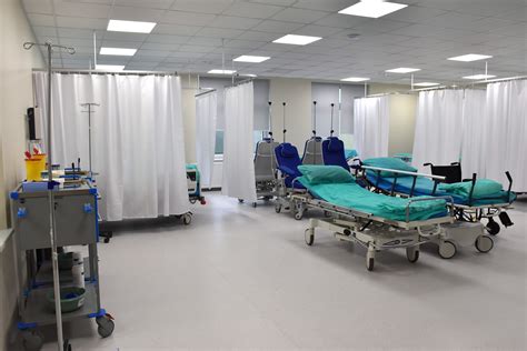 Erdvi patalpa su keliais lenktynių simuliatoriais, vaizduojanti modernų dizainą ir patogias sėdimas vietas.