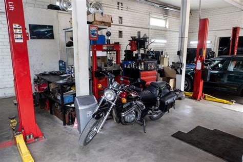 Teminė nuotrauka, vaizduojanti automobilių servisą su mechanikais, atliekančiais važiuoklės remontą