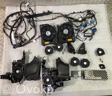 BMW garso sistemos komponentų išdėstymo schema automobilyje (priekinės durys, sėdynių subwooferiai, galinės durys)