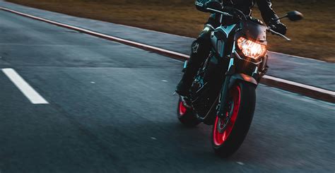 Motociklininkas važiuojantis atviru keliu saulėlydžio metu
