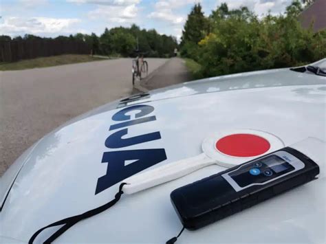 Teminis paveikslėlis: alkotesteris automobilyje, policijos automobilis fone