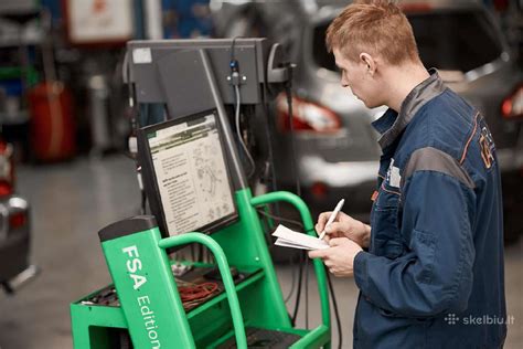 Profesionalus automobilių mechanikas, atliekantis diagnostiką automobilių servise