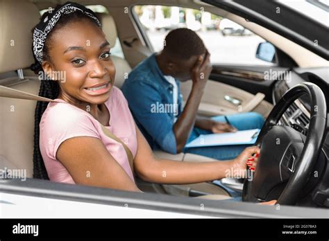 Thematic photo of a driving instructor explaining something to a student in a car.