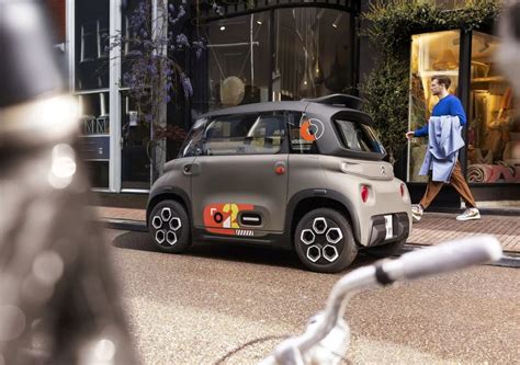 Tematinė nuotrauka: žmogus, vairuojantis mažą elektrinį automobilį mieste