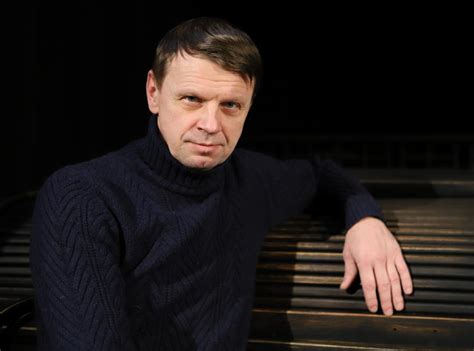 Portretas: Rolandas Kazlas ant teatro scenos, apšviestas prožektorių šviesos