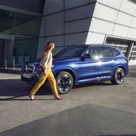 Meistras, konsultuojantis klientą prie BMW automobilio