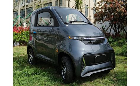 Kompaktiškas elektrinis automobilis, važiuojantis miesto gatve