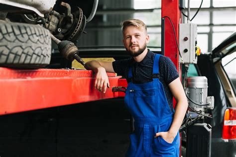 Mechanikas dirba po automobiliu, atjungdamas vairo mechanizmo dalis