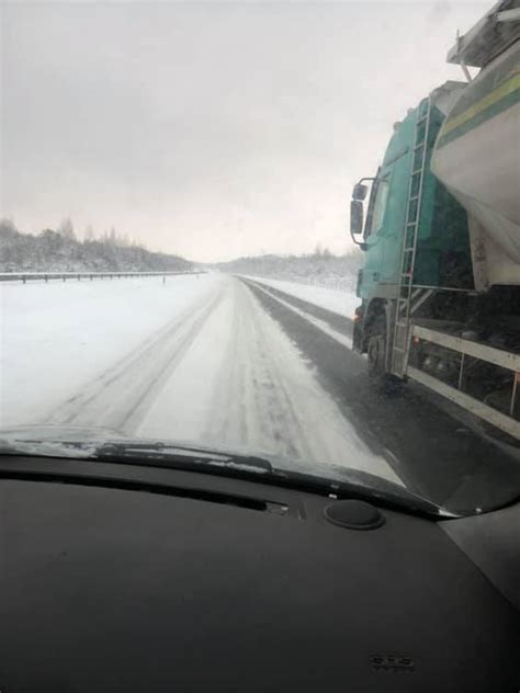 vaizdas, kuriame matomas Norvegijos kalnų kelias su sniegu ir apgadintas vilkikas