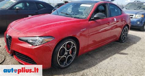 raudonos spalvos Alfa Romeo automobilio detali nuotrauka, atspindinti blizgesį ir kokybinę priežiūrą