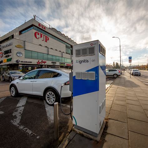 Teminė nuotrauka: elektromobilių įkrovimo stotelė su atitinkamu kelio ženklu