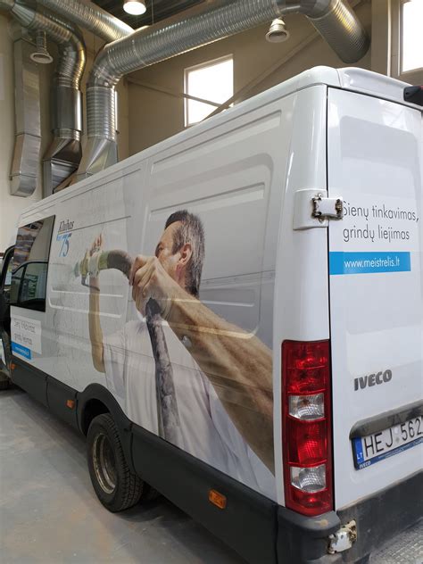 Automobilių serviso interjeras su specialistu prie Volvo automobilio
