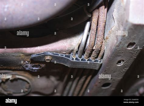 A close-up view of a severely corroded car wiper mechanism, highlighting rust buildup on the main axle and gear components.