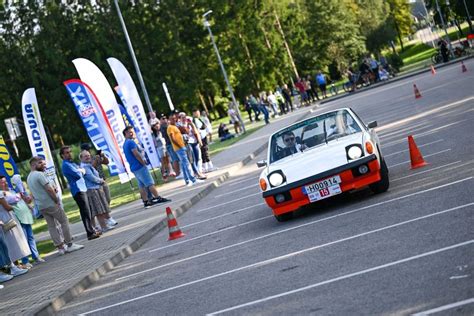 Istorinių lenktyninių automobilių nuotrauka su individualiais numeriais ir rėmėjų pavardėmis.
