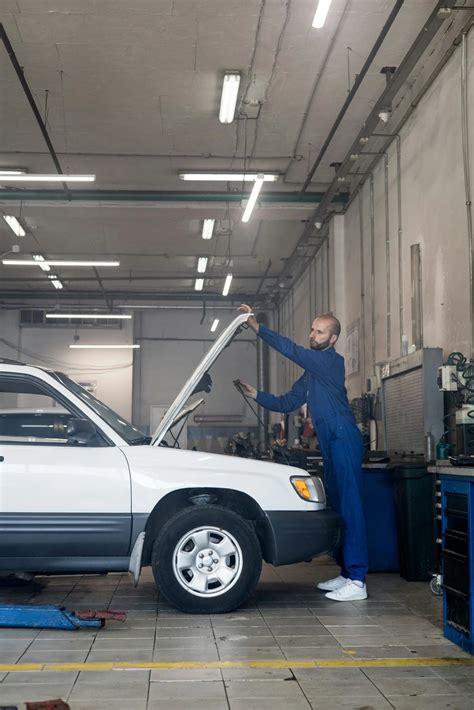 automobilio serviso patalpa su keltuvu ir meistrais, atliekančiais apžiūrą