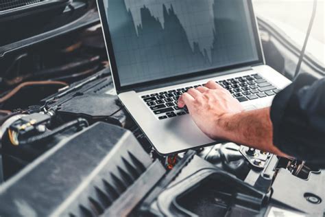 Meistras, atliekantis kompiuterinę diagnostiką Chrysler automobiliui.