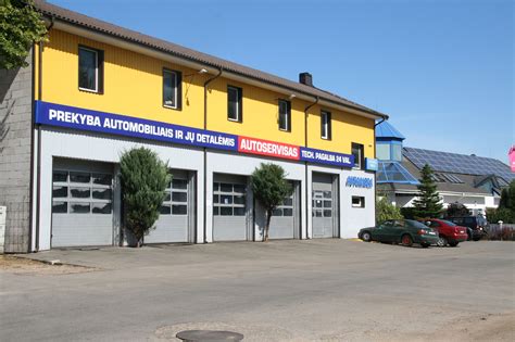 Tematinė nuotrauka: šiuolaikinis autoservisas su įranga ir dirbančiais meistrais