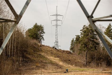 Teminė nuotrauka, iliustruojanti kraną, dirbantį šalia elektros linijų, su saugos ženklais