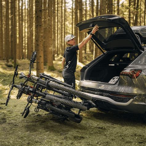 Nuotrauka, demonstruojanti Thule dviračių laikiklį ant automobilio kablio su atidaryta bagažine