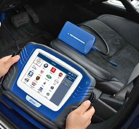 meistras atlieka kompiuterinę diagnostiką automobiliui