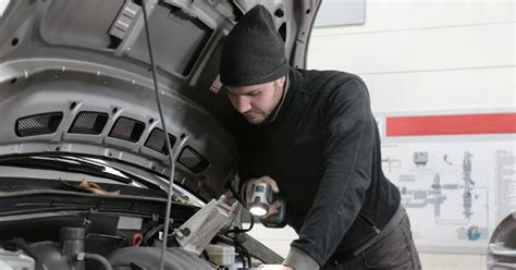 Tematinė iliustracija: Mechanikas tikrina darbinį veleną po transporto priemone