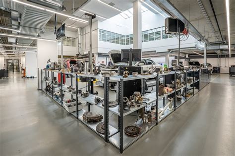 Automobilių detalių parduotuvės interjeras su darbuotoju konsultuojančiu klientą