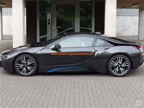 Sportinis hibridas BMW i8 su atidarytomis durelėmis modernioje aplinkoje