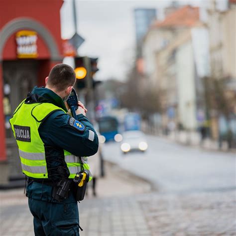Teminė nuotrauka: vairuotojas rodo dokumentus policijos pareigūnui.