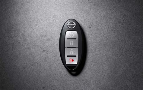 Nissan X-Trail raktelio nuotrauka su iškylančiu įspėjimu apie žemą baterijos lygį